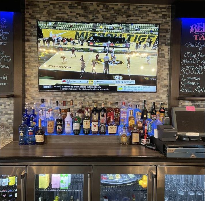Sports bar: Commercial install over a lit back bar.