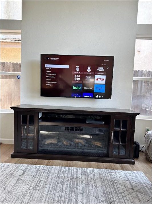 Wall-mounted TV above a console installed by Kalieb Designs